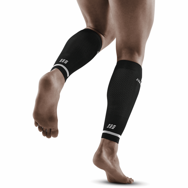 Black CEP The Run Compression Calf Sleeves 4.0 for men, shown on a model, highlighting the snug fit and breathable fabric.