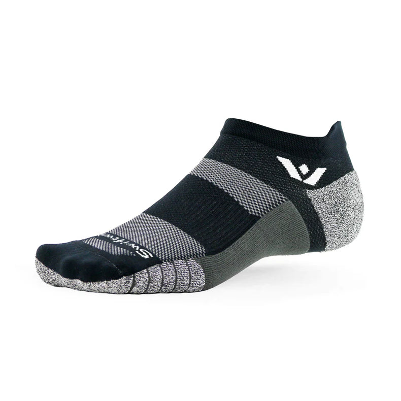 Black Swiftwick Flite XT no-show tab socks displayed on foot, highlighting lightweight athletic sock design and branding details.