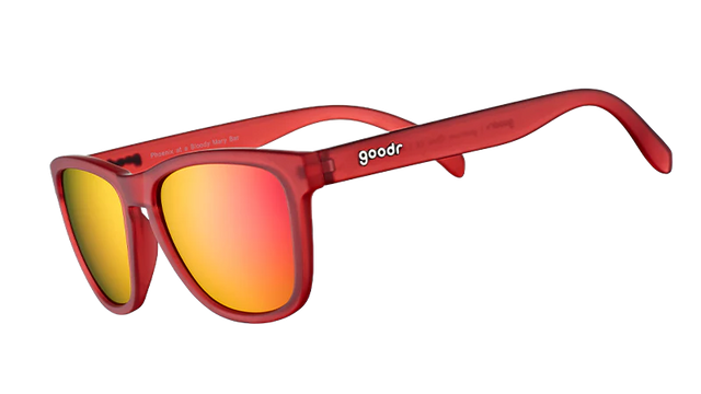 GOODR Phoenix sunglasses with transparent frame and colorful lens, shown at a Bloody Mary bar setting.